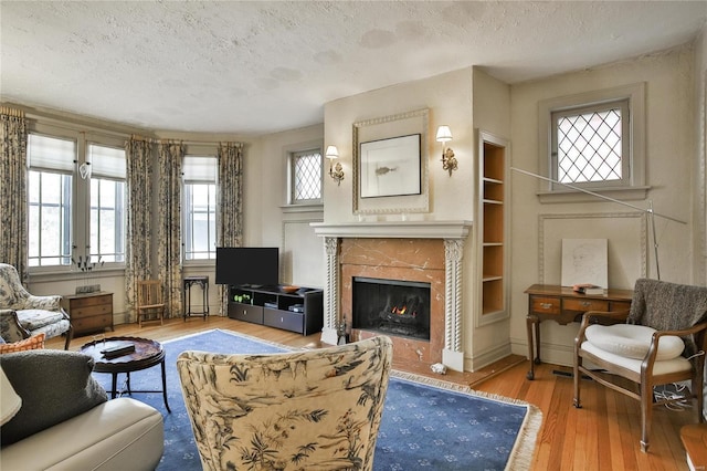 living area with a textured ceiling, wood finished floors, and a healthy amount of sunlight