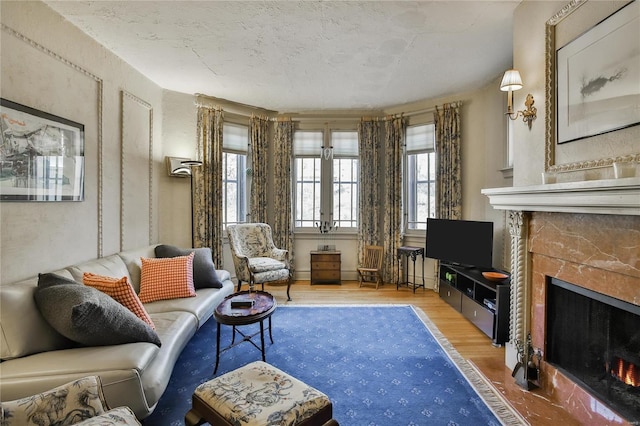 living area with a fireplace with flush hearth and wood finished floors