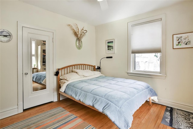 bedroom with ceiling fan, baseboards, and wood finished floors