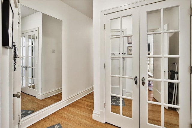 interior space with french doors, wood finished floors, and baseboards