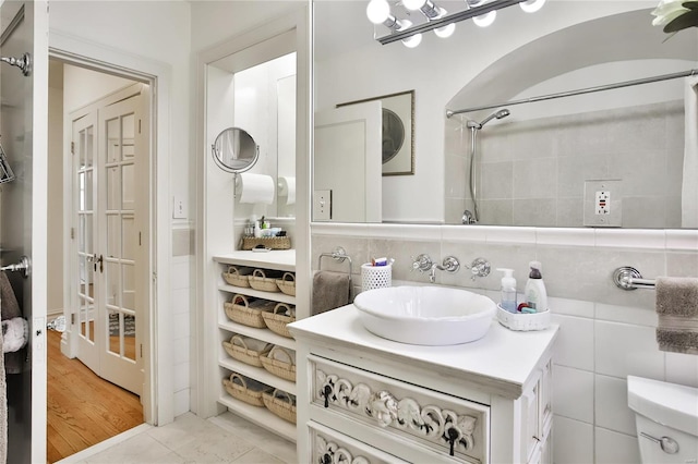 full bathroom featuring tile walls, backsplash, and vanity