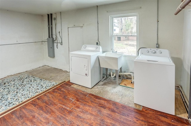 laundry room featuring hardwood / wood-style flooring, separate washer and dryer, electric panel, and sink