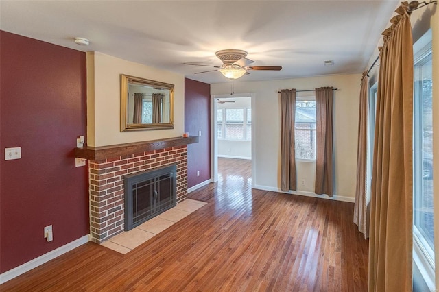 unfurnished living room featuring ceiling fan, a fireplace, and hardwood / wood-style floors