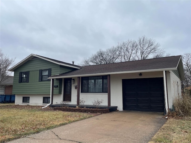 split level home featuring a garage and a front lawn