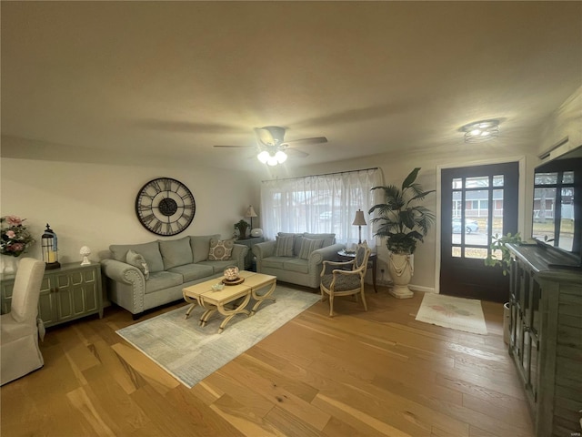 living room featuring light hardwood / wood-style flooring, ceiling fan, and plenty of natural light