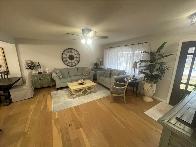 living room with light hardwood / wood-style flooring and ceiling fan