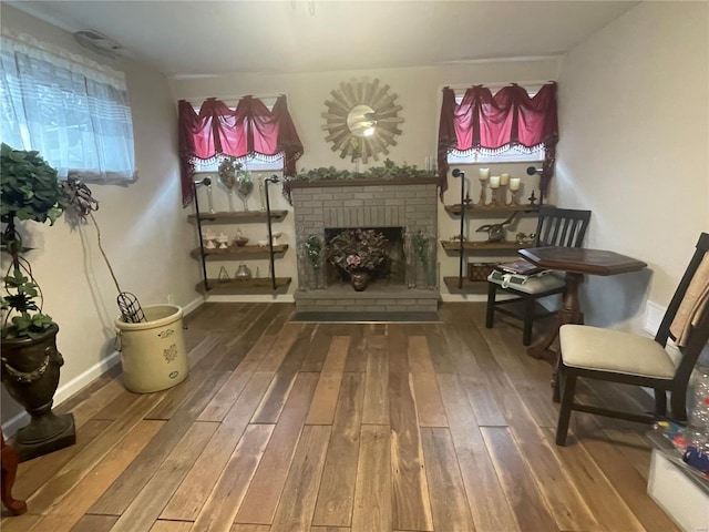 living area with a fireplace and wood-type flooring