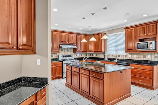 kitchen with pendant lighting, a kitchen island with sink, stainless steel appliances, light tile patterned flooring, and dark stone counters