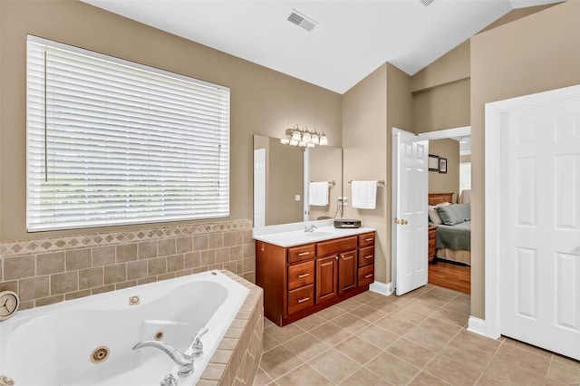 bathroom featuring lofted ceiling, vanity, tile patterned floors, and tiled tub