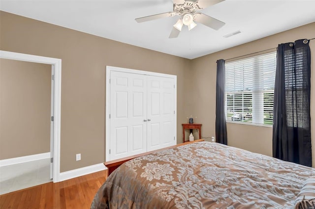 bedroom featuring wood-type flooring, a closet, and ceiling fan