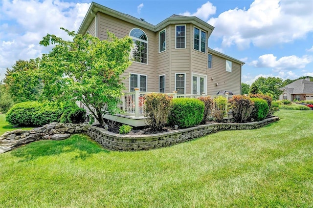 back of property featuring a yard and a deck