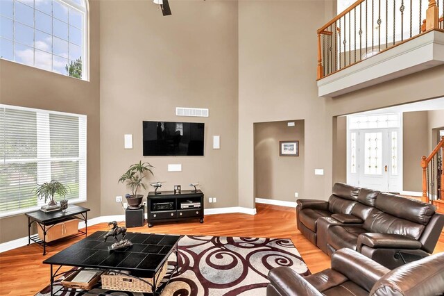 living room featuring hardwood / wood-style flooring and a high ceiling