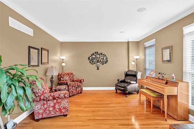 living area with crown molding and wood-type flooring