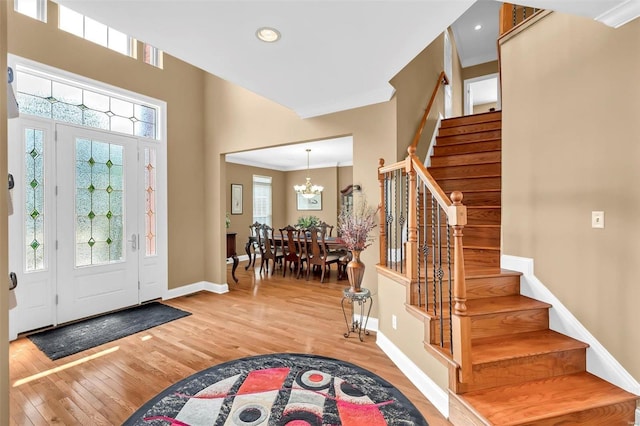 entrance foyer featuring an inviting chandelier, crown molding, and wood-type flooring