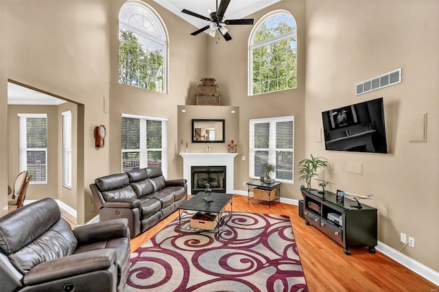 living room with hardwood / wood-style floors, crown molding, and ceiling fan