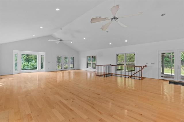 unfurnished living room featuring ceiling fan, high vaulted ceiling, and light wood-type flooring