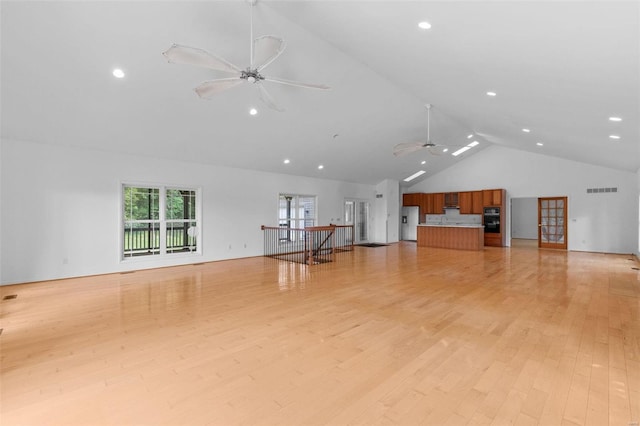 unfurnished living room featuring high vaulted ceiling, light wood-type flooring, and ceiling fan