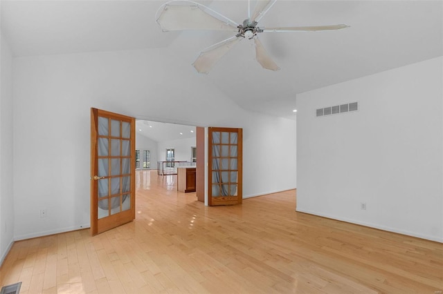 spare room with french doors, ceiling fan, lofted ceiling, and light wood-type flooring