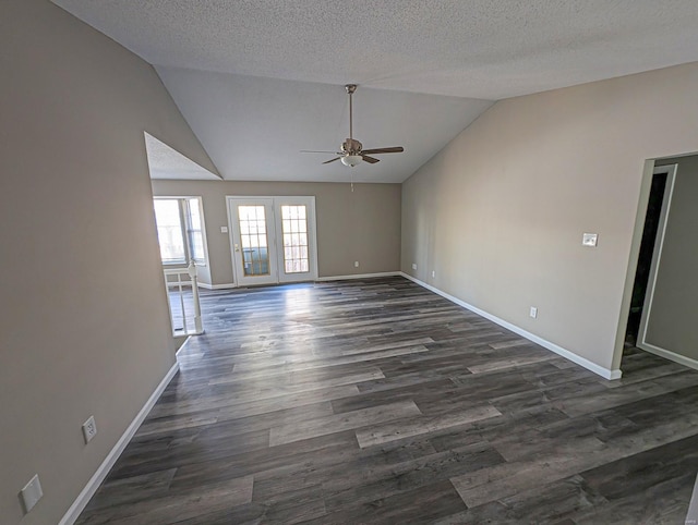 unfurnished living room with ceiling fan, dark hardwood / wood-style floors, vaulted ceiling, and a textured ceiling