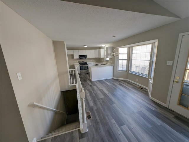 kitchen featuring sink, white cabinetry, decorative light fixtures, appliances with stainless steel finishes, and dark hardwood / wood-style flooring