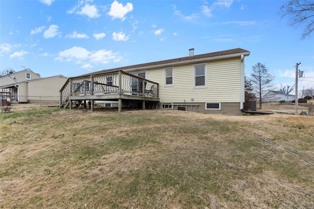 rear view of property with a wooden deck and a yard