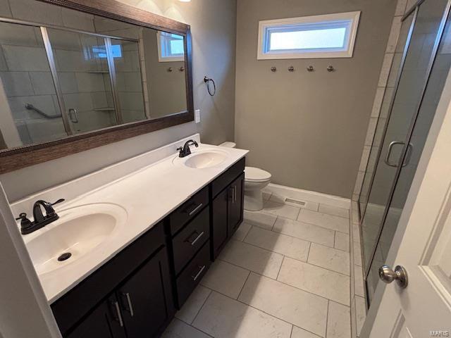 bathroom with tile patterned flooring, toilet, vanity, and walk in shower