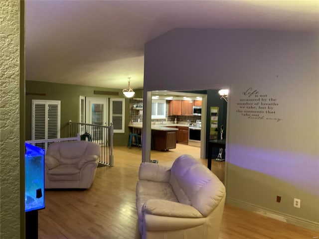 living room featuring vaulted ceiling and light hardwood / wood-style floors