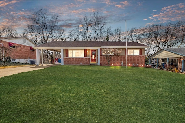 single story home featuring a carport and a yard