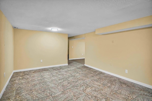 unfurnished room with a textured ceiling