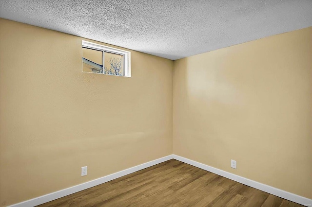 empty room with hardwood / wood-style floors and a textured ceiling