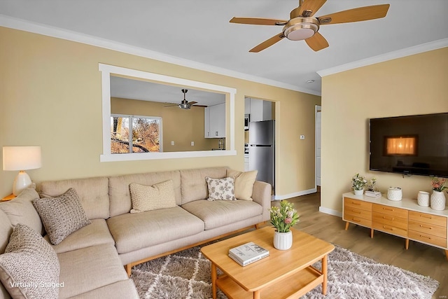 living room featuring hardwood / wood-style floors, crown molding, and ceiling fan