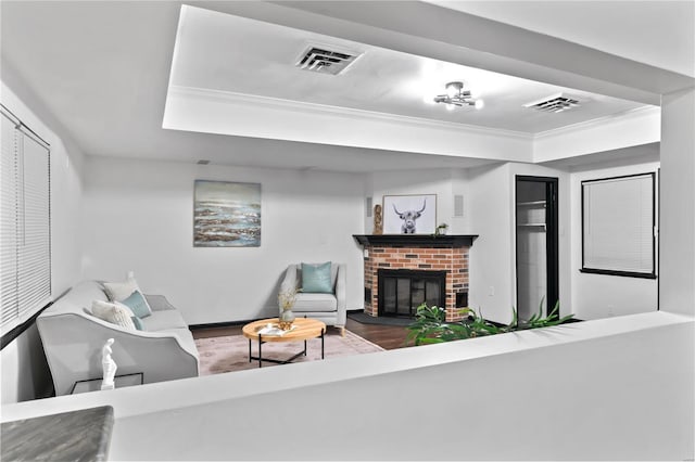 living room featuring crown molding, a fireplace, and wood-type flooring