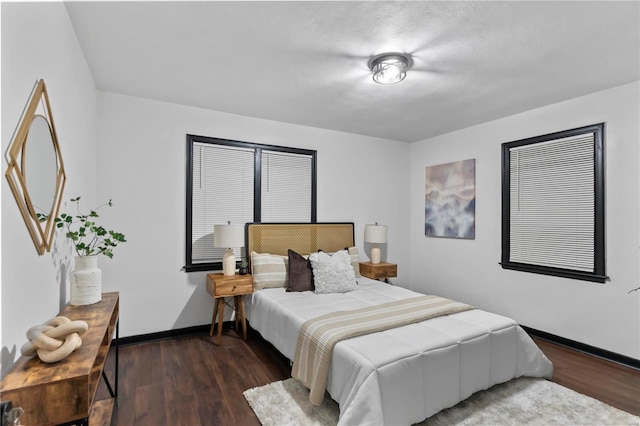 bedroom with dark hardwood / wood-style floors