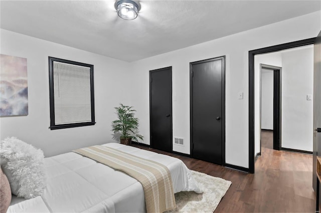 bedroom with dark hardwood / wood-style flooring