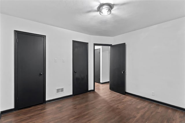 unfurnished bedroom featuring dark hardwood / wood-style flooring