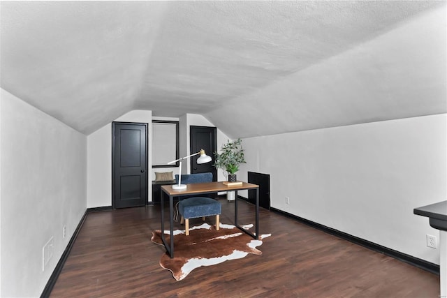 office featuring dark hardwood / wood-style floors, vaulted ceiling, and a textured ceiling