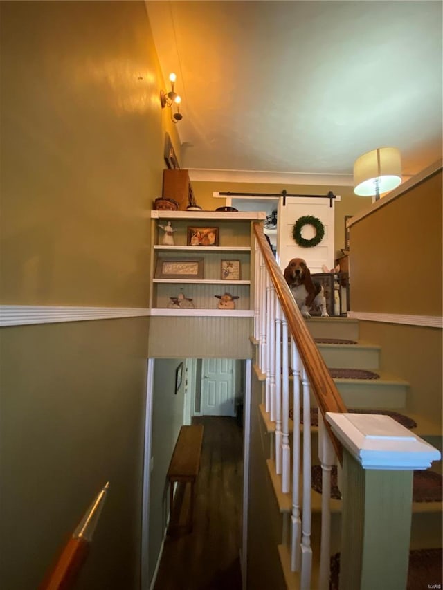 stairway with hardwood / wood-style flooring and a barn door