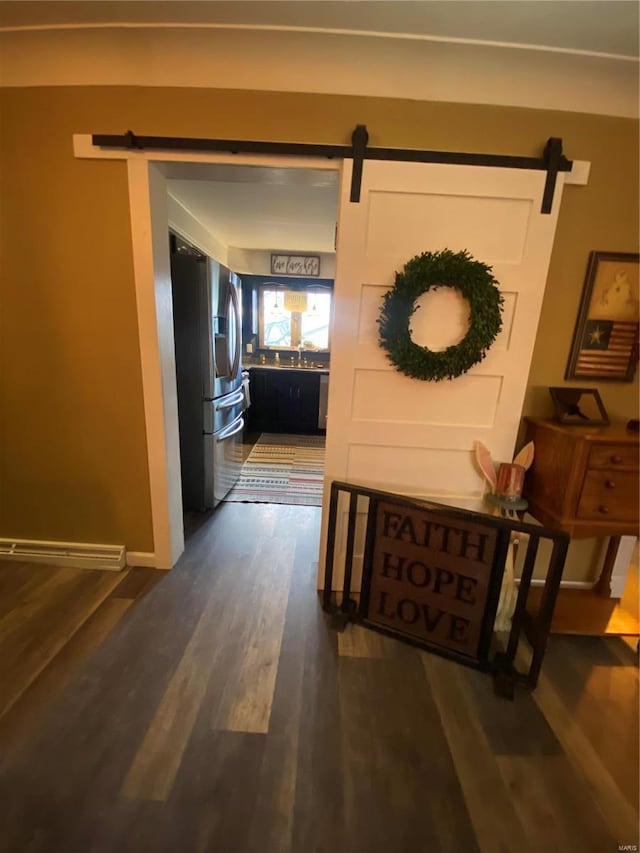 corridor with dark wood-type flooring, a barn door, and sink