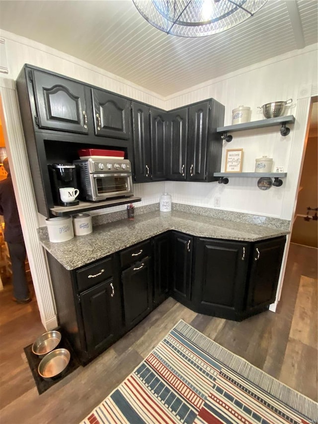 kitchen featuring hardwood / wood-style flooring and dark stone counters