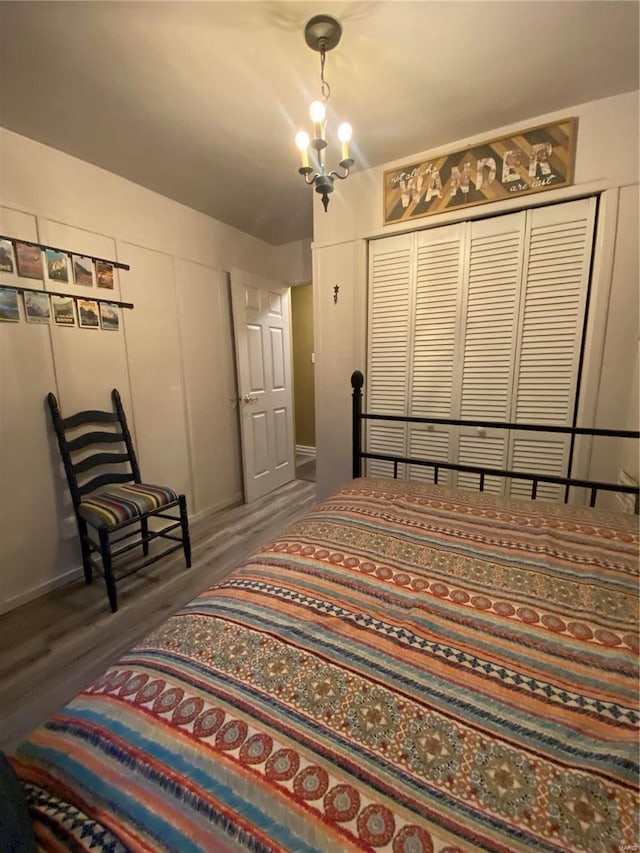 bedroom with a notable chandelier and dark wood-type flooring