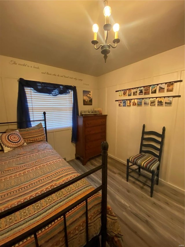 bedroom with wood-type flooring and an inviting chandelier