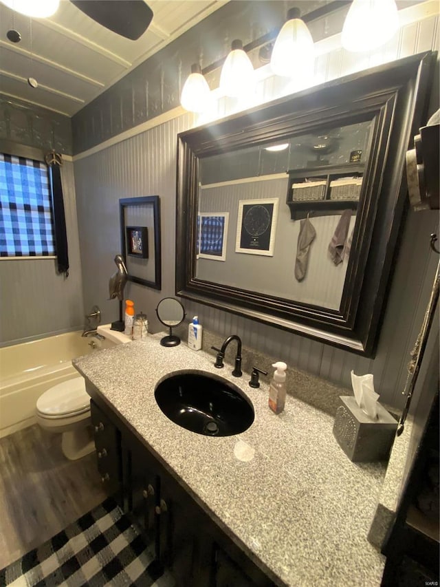 full bathroom with shower / tub combination, vanity, toilet, and wood-type flooring