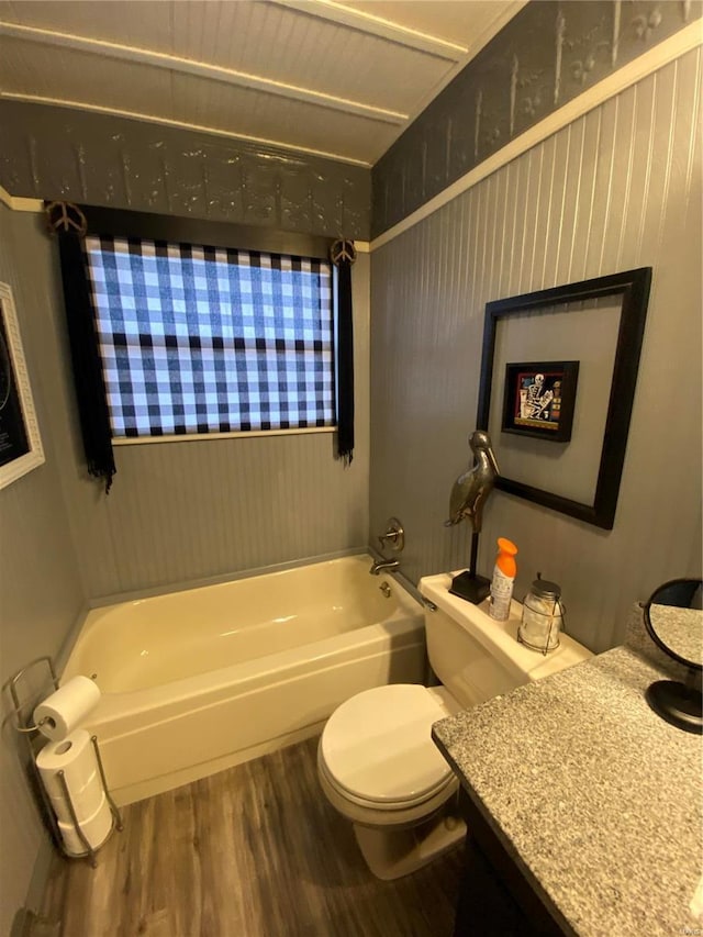 bathroom with hardwood / wood-style flooring, vanity, toilet, and a bathing tub