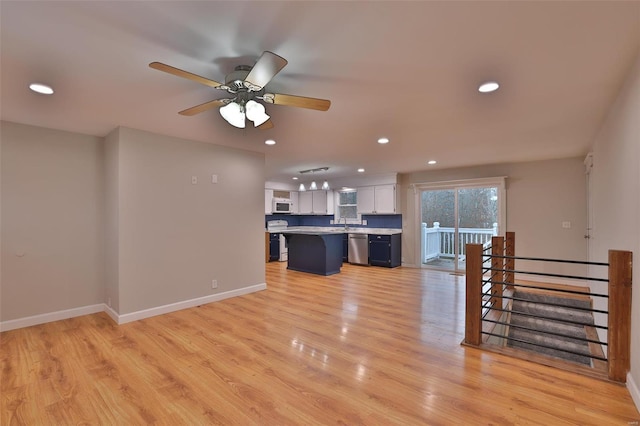 unfurnished living room featuring light hardwood / wood-style flooring and ceiling fan