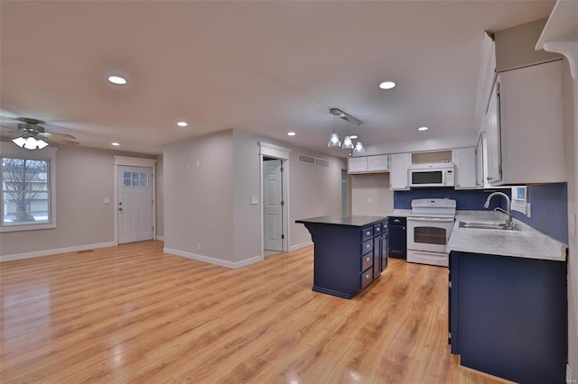 kitchen with sink, white appliances, hanging light fixtures, a kitchen island, and blue cabinets