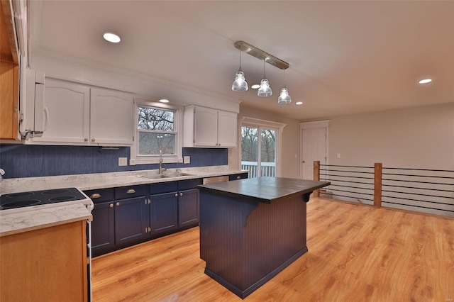 kitchen with blue cabinets, sink, white cabinetry, decorative light fixtures, and a center island