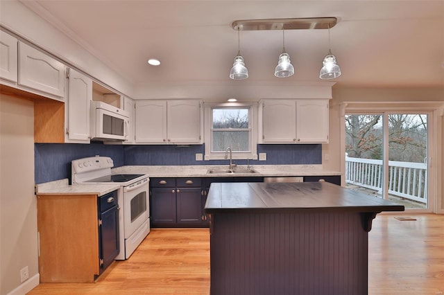 kitchen featuring pendant lighting, sink, white appliances, and white cabinets