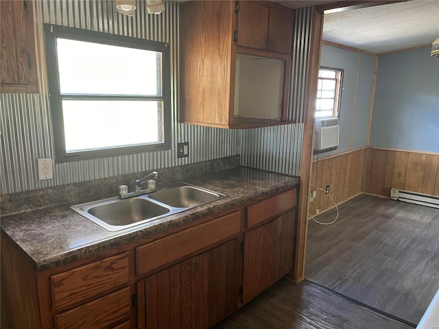 kitchen featuring dark wood-type flooring, sink, a textured ceiling, baseboard heating, and cooling unit