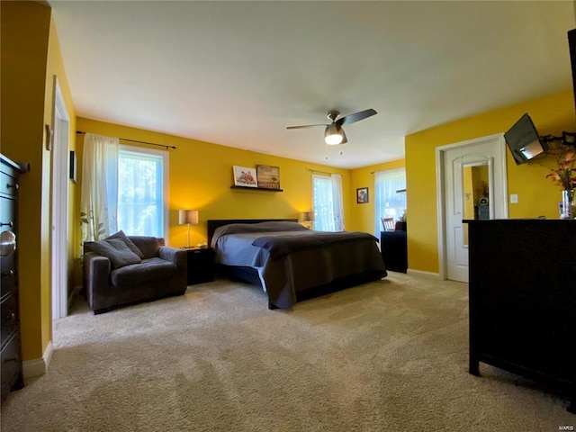 bedroom featuring light colored carpet and ceiling fan