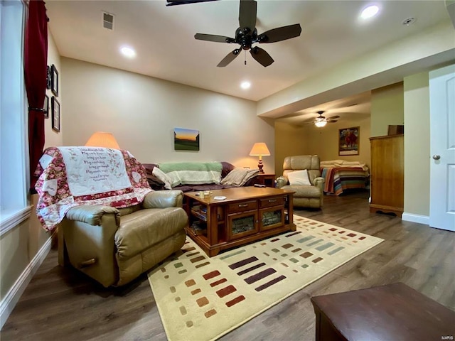 living room featuring dark wood-type flooring and ceiling fan